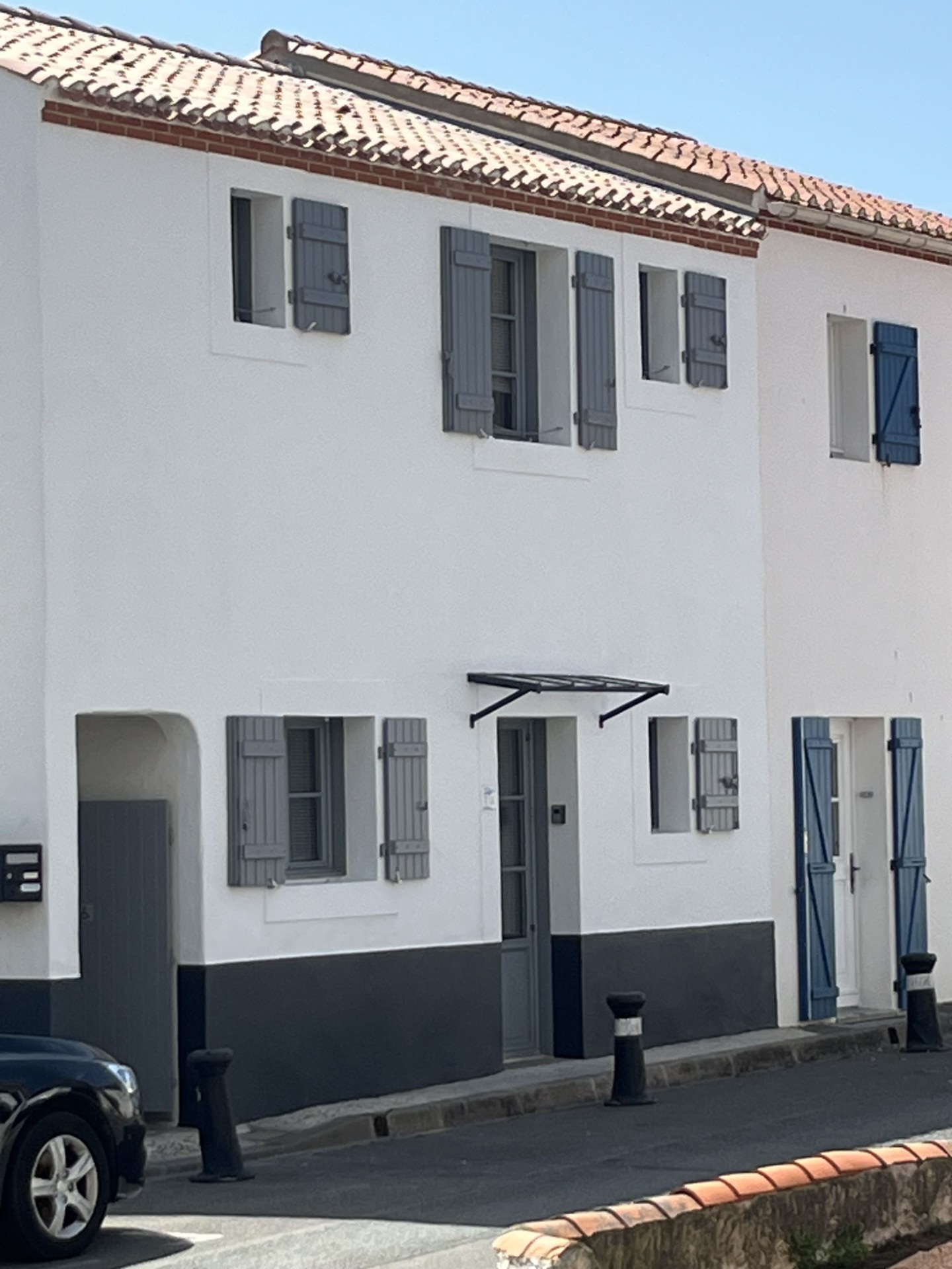 Façade blanche avec soubassement gris rénové